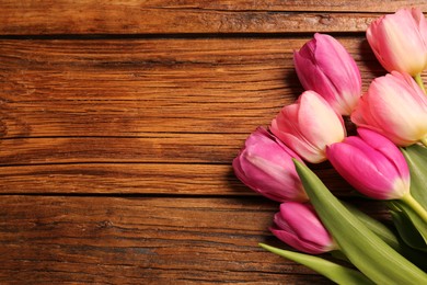 Beautiful colorful tulip flowers on wooden table, flat lay. Space for text