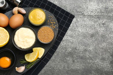 Delicious homemade mayonnaise, spices and ingredients on grey table, top view. Space for text