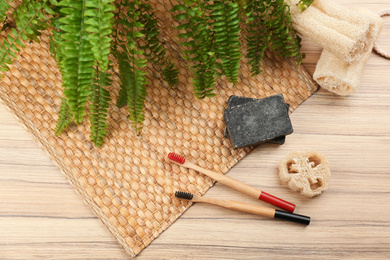 Flat lay composition with natural bamboo toothbrushes on wooden table