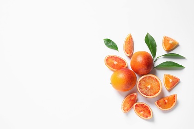 Photo of Fresh bloody oranges and leaves on white background, top view. Citrus fruits