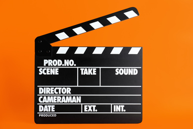 Photo of Clapper board on orange background. Cinema production