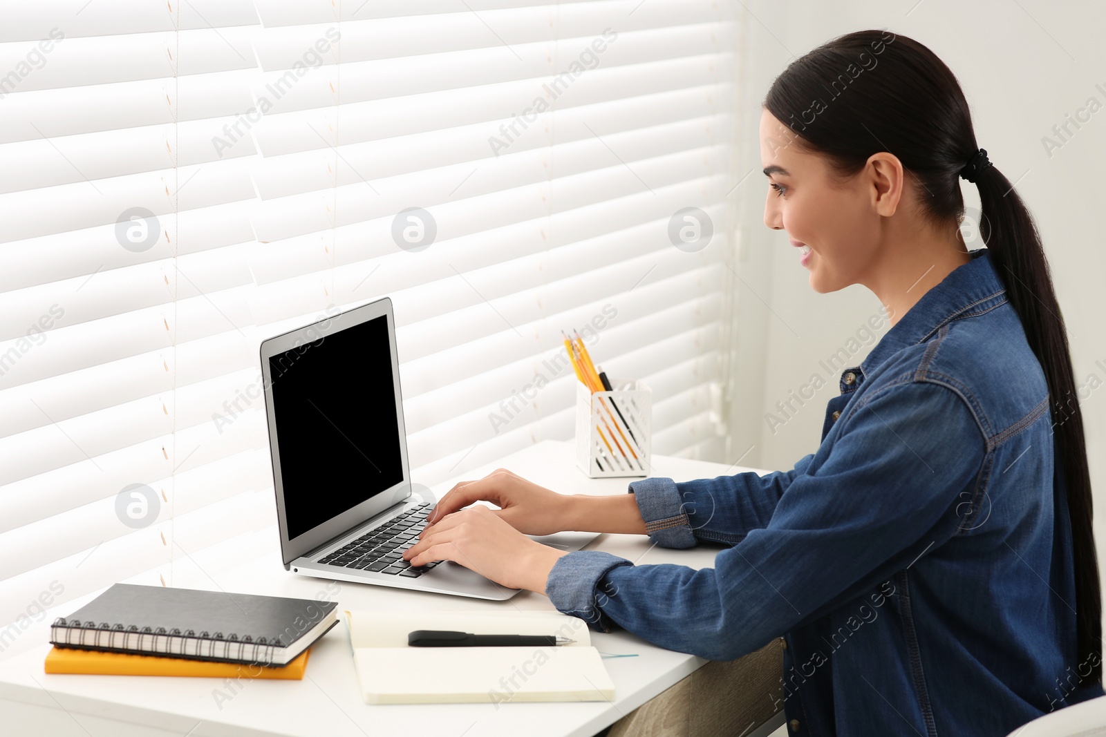 Photo of Online translation course. Student typing on laptop at home