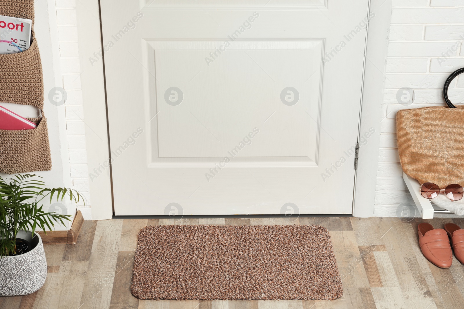 Photo of Clean door mat on wooden floor in hall