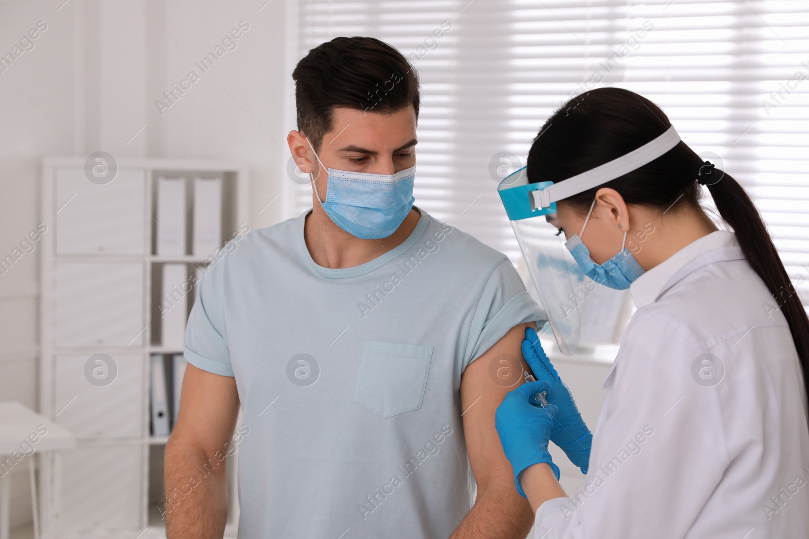 Photo of Doctor giving injection to patient in hospital. Vaccination campaign