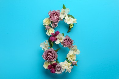 Photo of Number 8 made of beautiful flowers on light blue background, flat lay. International Women's day