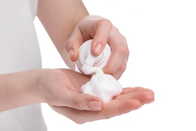 Photo of Woman applying cleansing foam onto hand on white background, closeup