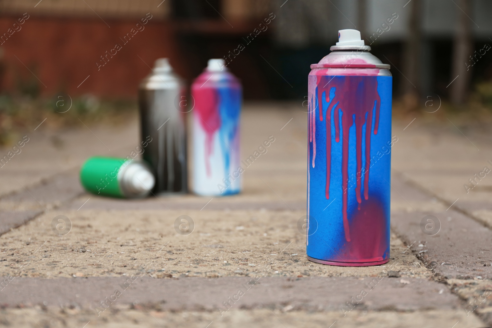 Photo of Used can of spray paint on city street. Space for text