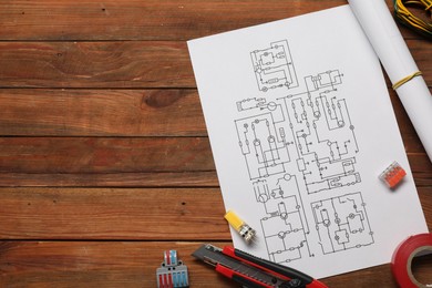 Photo of Wiring diagram, knife, different electrician's equipment and insulating tape on wooden table, flat lay. Space for text