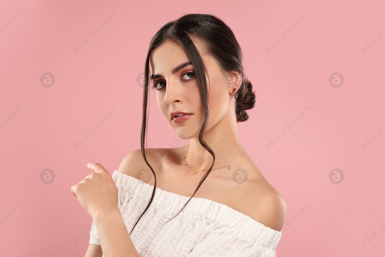 Photo of Beautiful woman with elegant jewelry on pink background