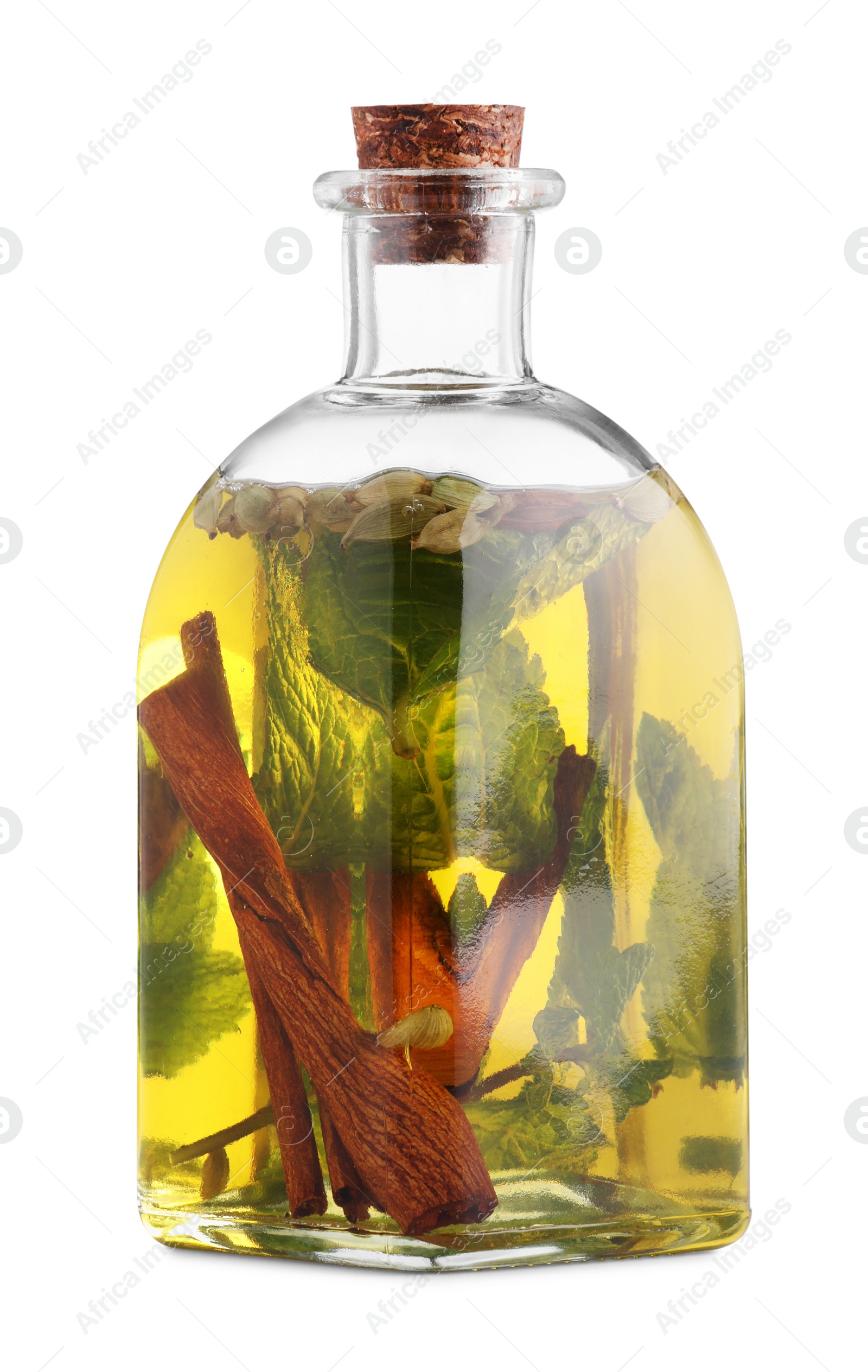 Photo of Glass bottle of cooking oil with spices and herbs isolated on white