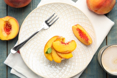 Photo of Delicious peach dessert on blue wooden table, flat lay
