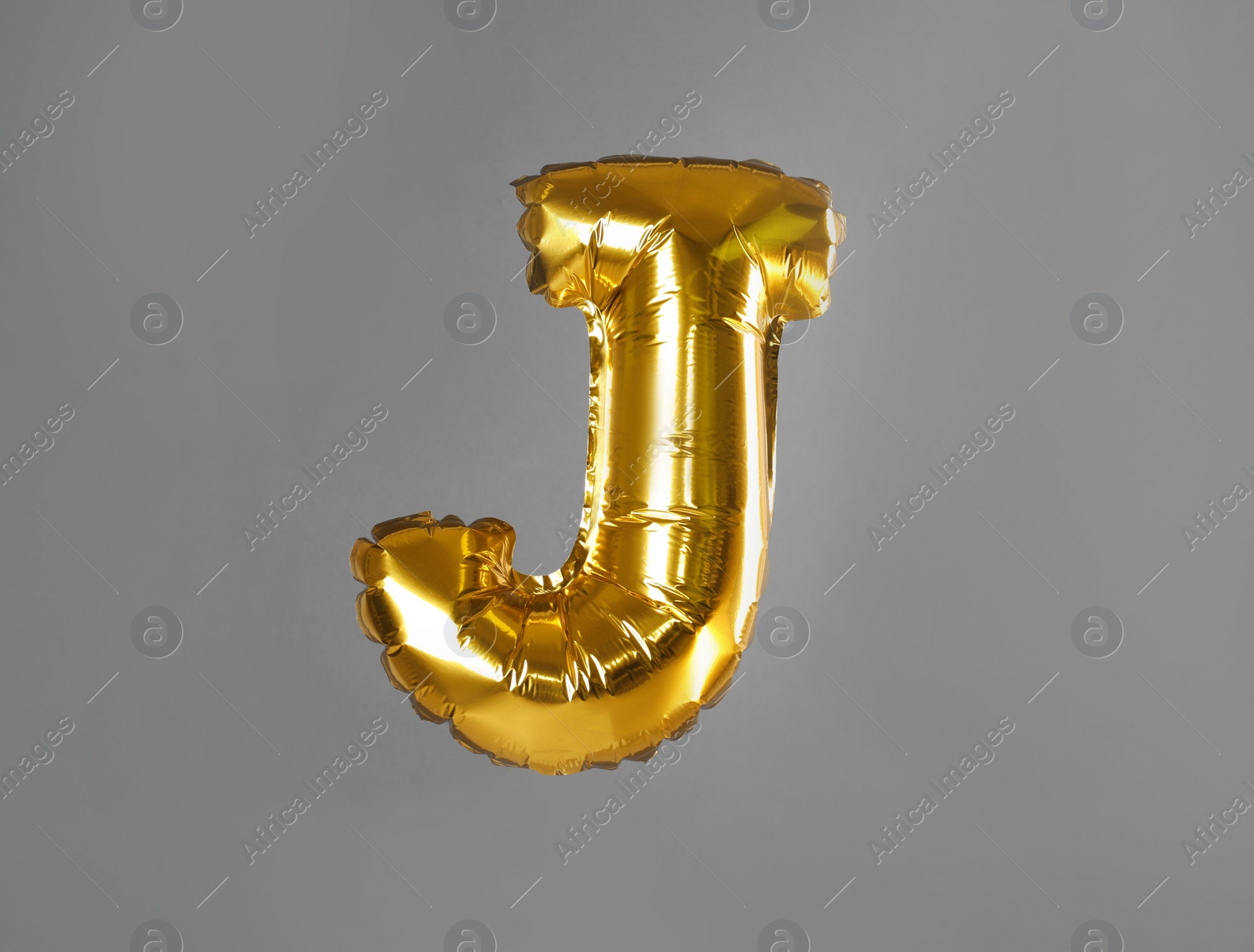 Photo of Golden letter J balloon on grey background