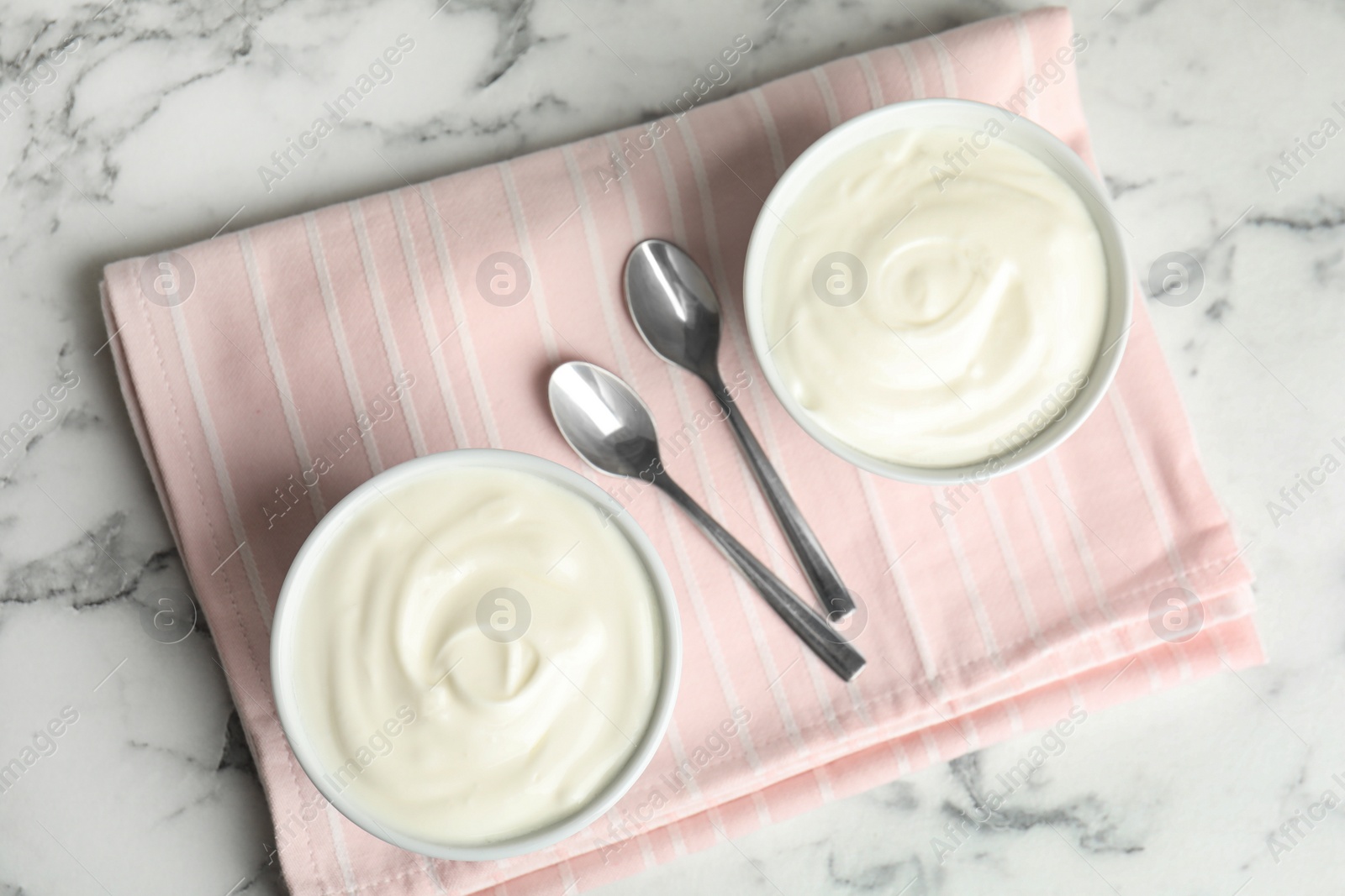 Photo of Tasty organic yogurt on white marble table, top view