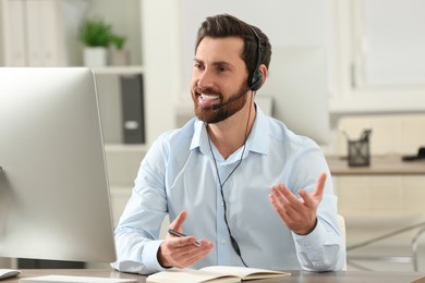 Hotline operator with headset working in office