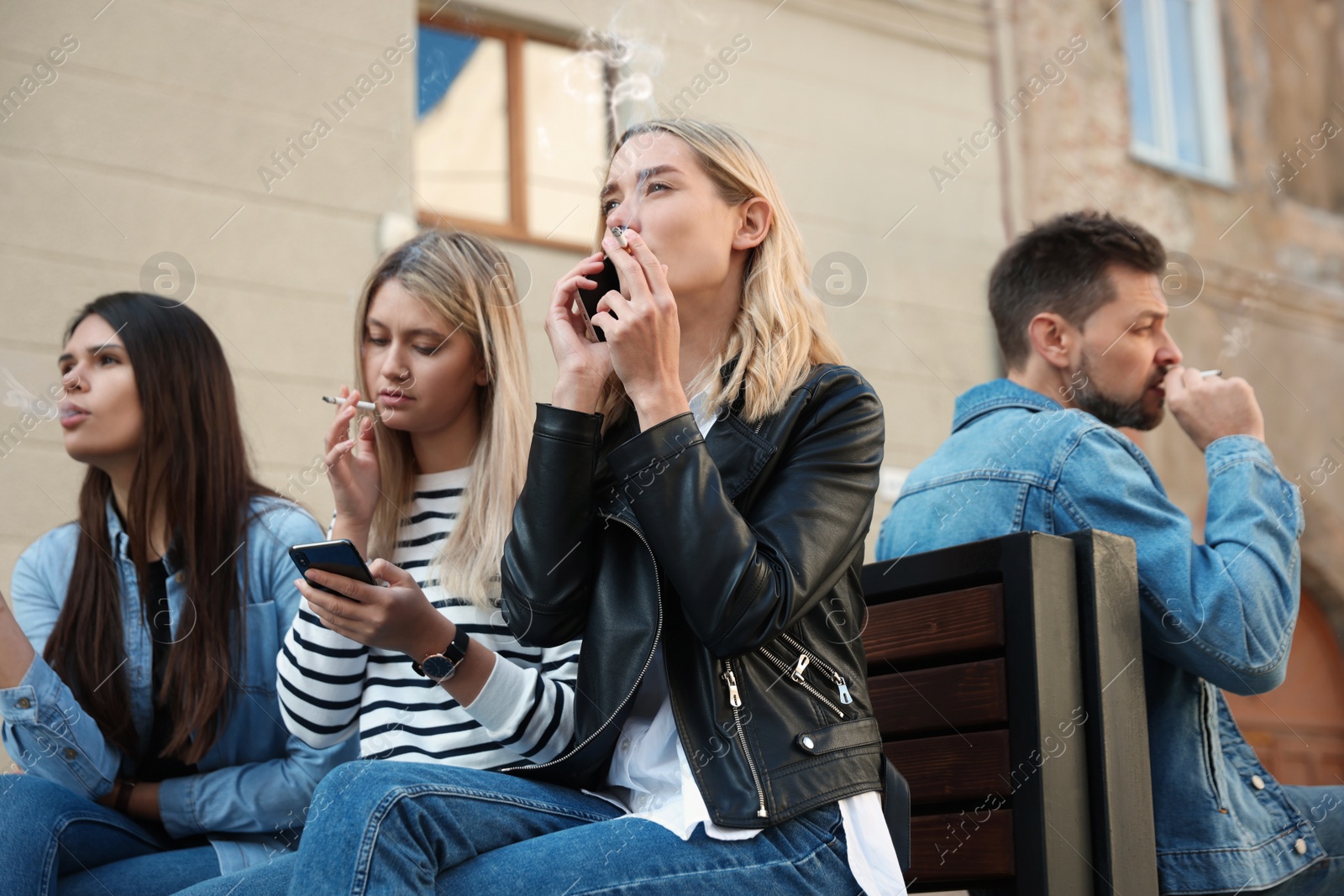 Photo of People smoking cigarettes at public place outdoors