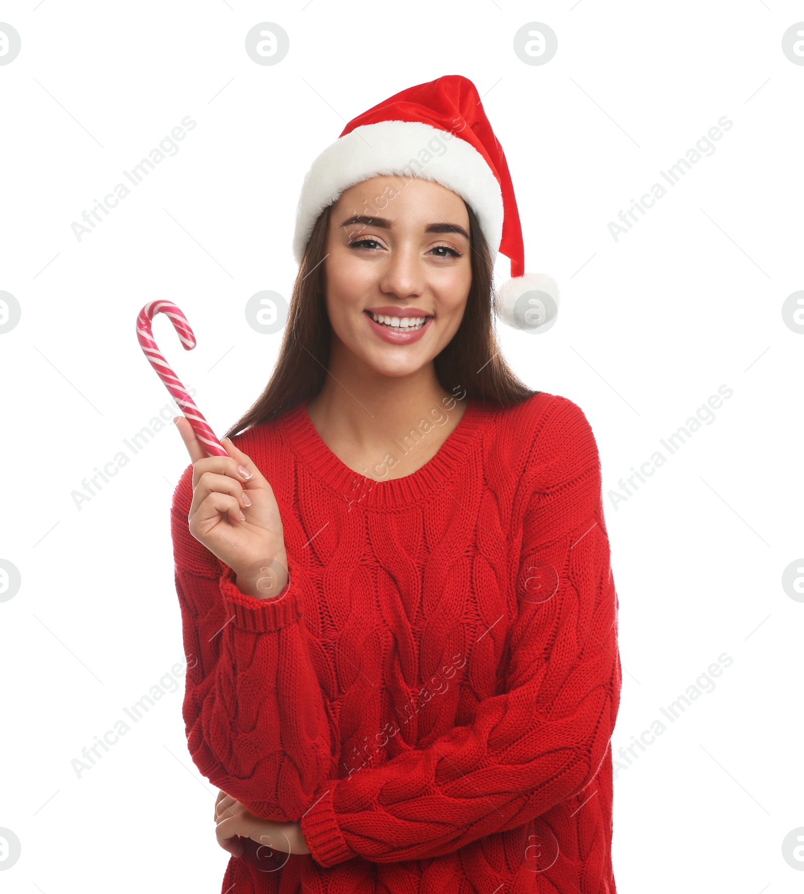 Photo of Young woman in red sweater and Santa hat holding candy cane on white background. Celebrating Christmas