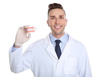 Photo of Male dentist holding model of oral cavity with teeth on white background
