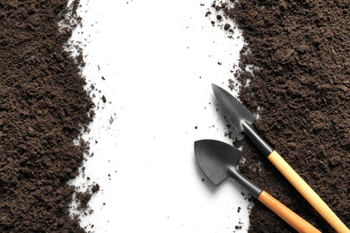 Flat lay composition with gardening tools and soil on light background