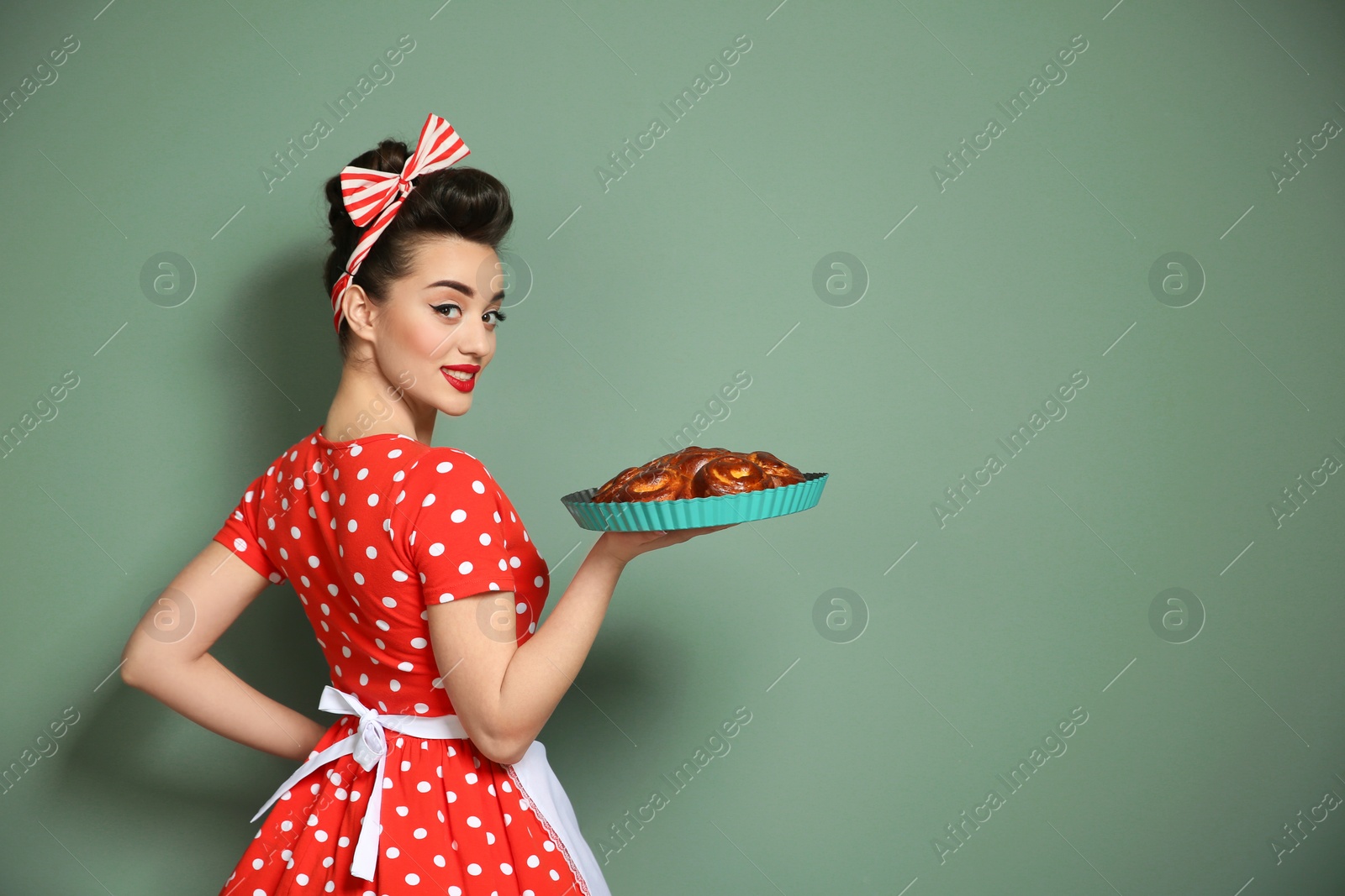 Photo of Funny young housewife with homemade pastry on color background