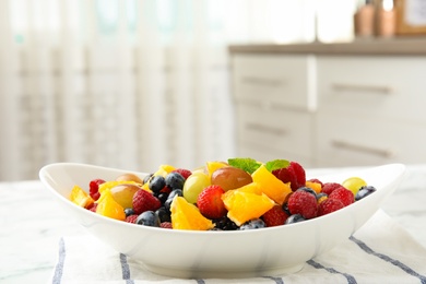 Fresh tasty fruit salad on table in kitchen