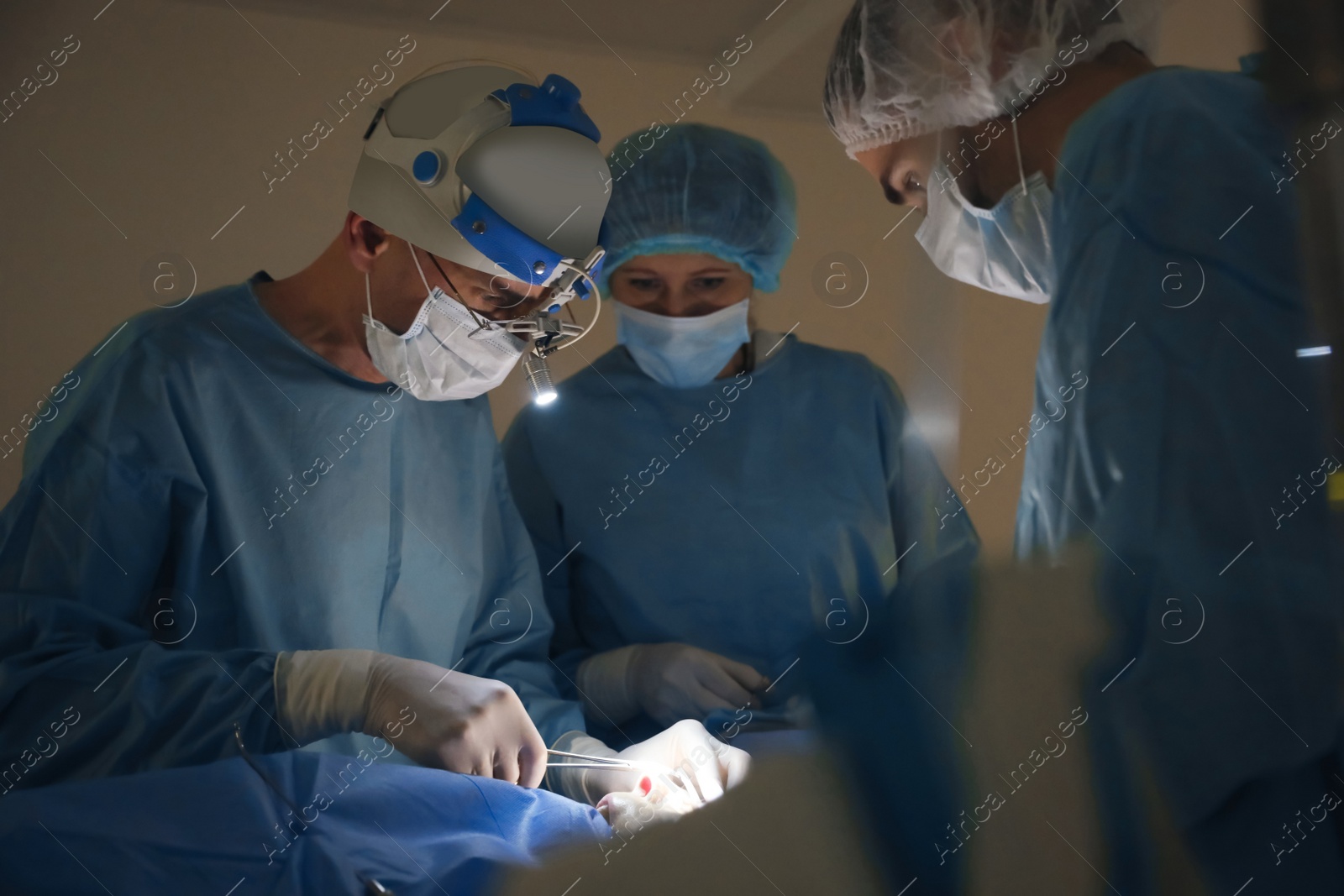 Photo of Professional doctors performing 
frontal sinus trephination in surgery room