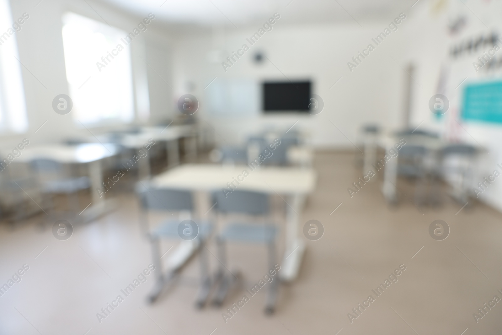 Photo of Blurred view of empty school classroom with desks and chairs