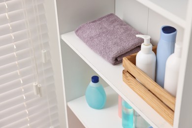 Photo of Fresh towel and toiletries on shelf indoors, above view