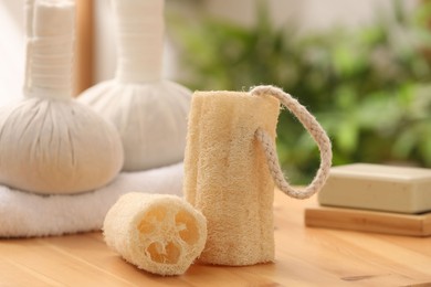 Photo of Loofah sponges on wooden table indoors, closeup. Personal hygiene products