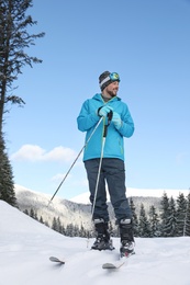 Man with ski equipment spending winter vacation in mountains