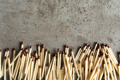 Photo of Many matches on grey background, top view with space for text