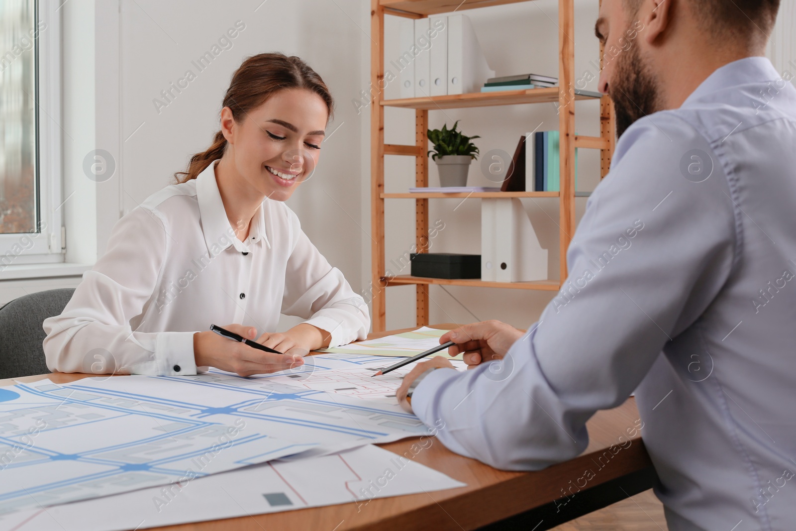 Photo of Professional cartographers working with cadastral map at table in office