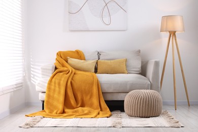 Photo of Cozy orange plaid on sofa in living room