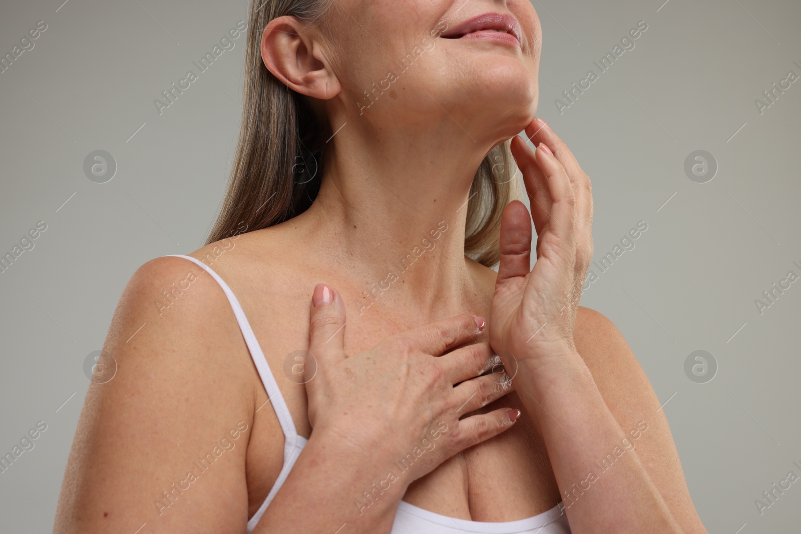 Photo of Woman with healthy skin on grey background, low angle view