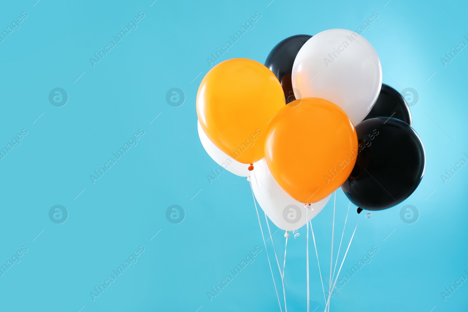 Photo of Colorful balloons on blue background, space for text. Halloween party