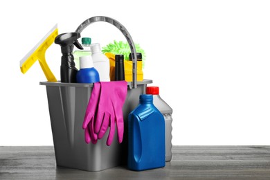 Photo of Grey bucket with car care products on wooden table against white background