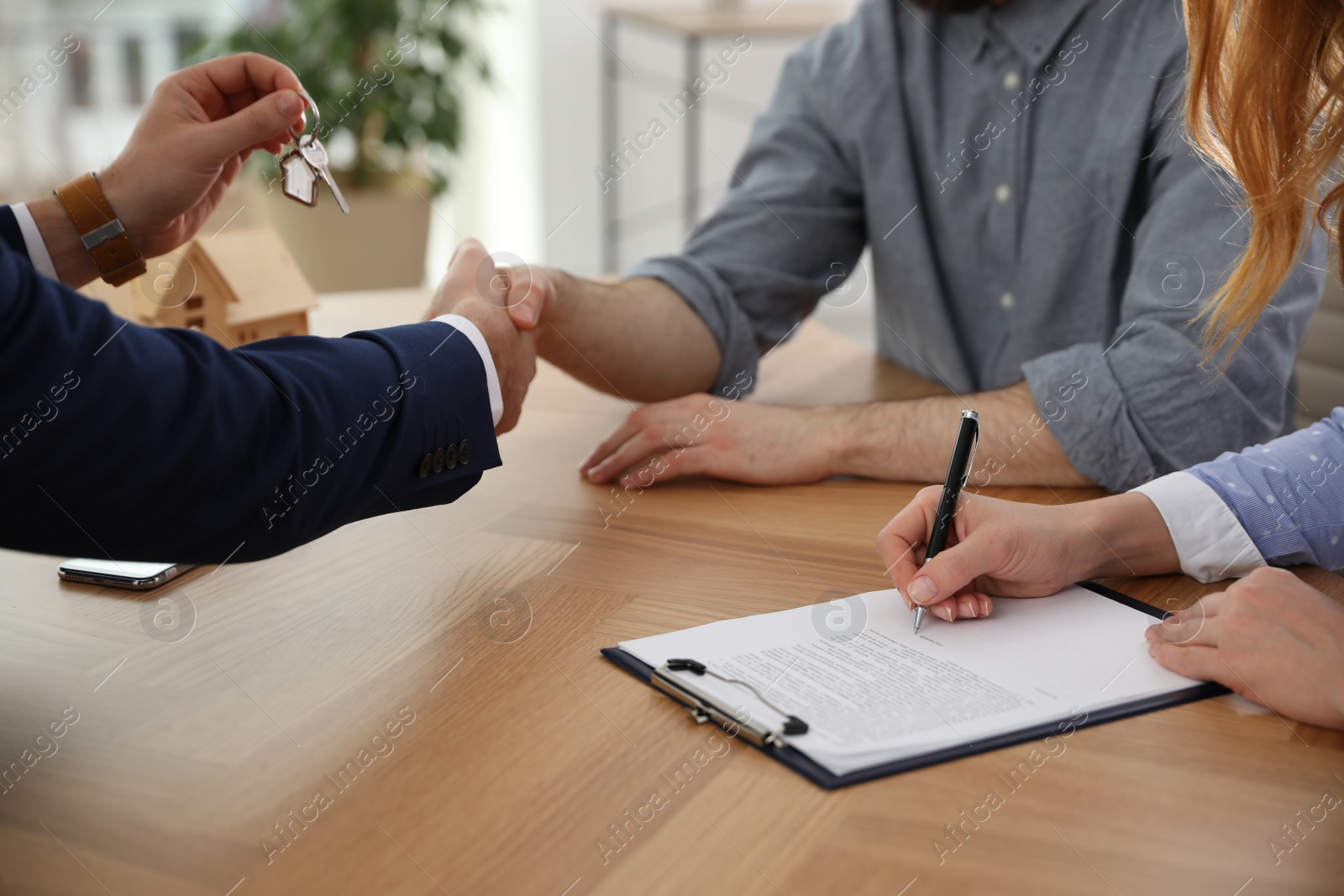 Photo of Real estate agent working with clients in office, closeup