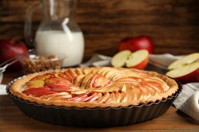 Photo of Delicious homemade apple tart on wooden table