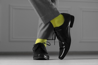 Photo of Man wearing stylish shoes and yellow socks indoors, closeup