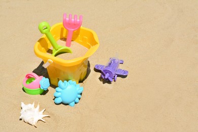 Photo of Set of plastic beach toys on sand, space for text