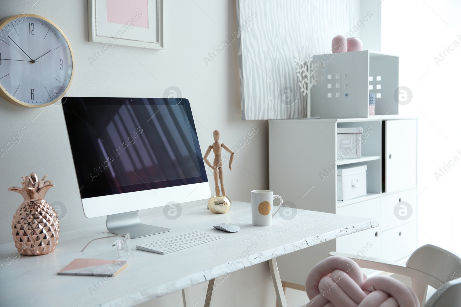 Photo of Contemporary workplace with computer on table near white wall. Interior design