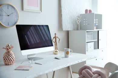 Contemporary workplace with computer on table near white wall. Interior design