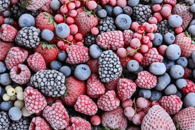 Photo of Mix of different frozen berries as background, top view