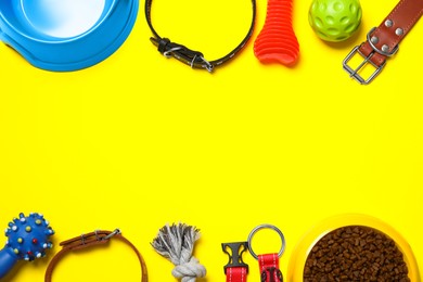 Flat lay composition with dog collar, toys and food on yellow background. Space for text