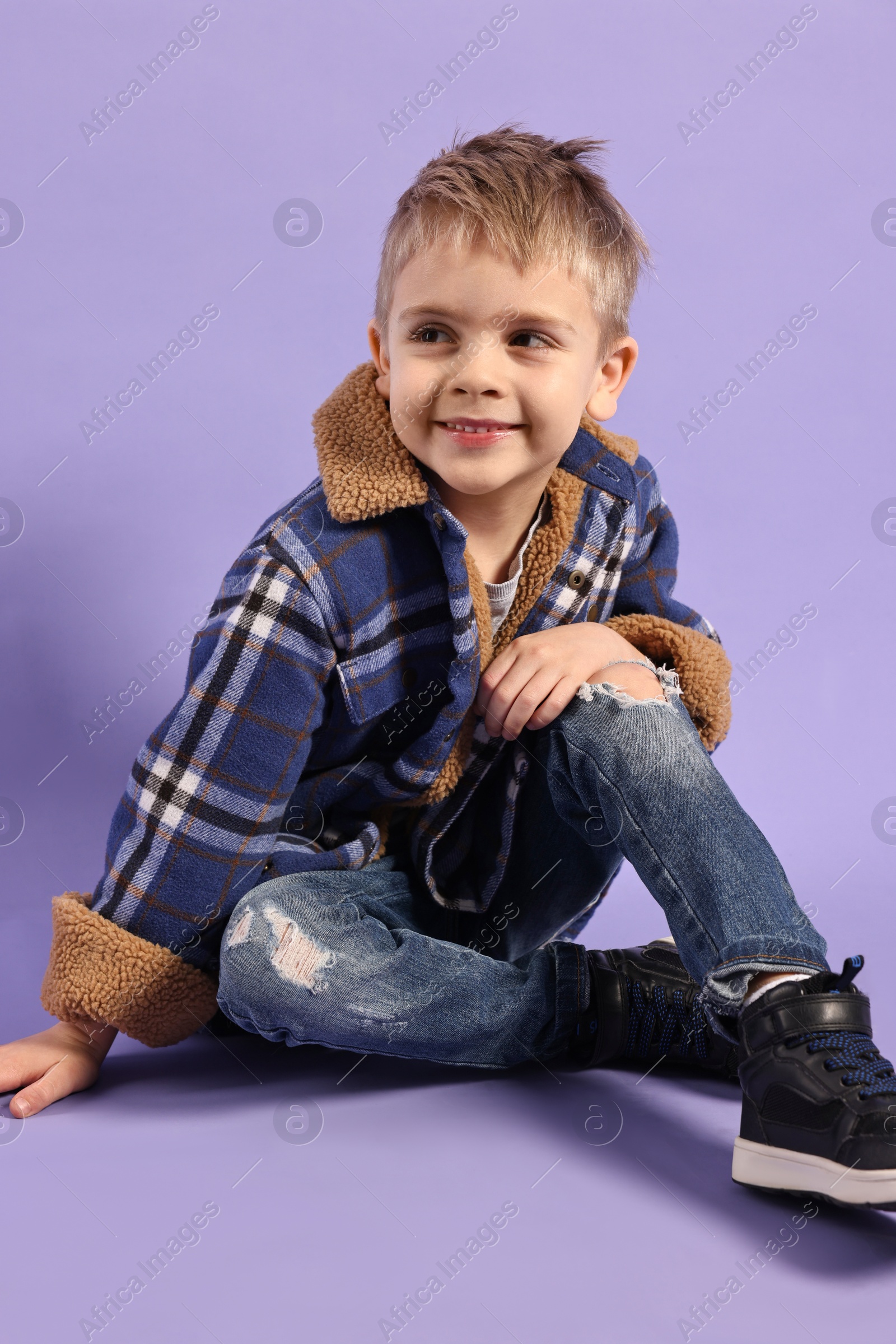 Photo of Fashion concept. Stylish boy posing on violet background