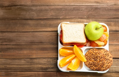 Photo of Lunch box with appetizing food on wooden table
