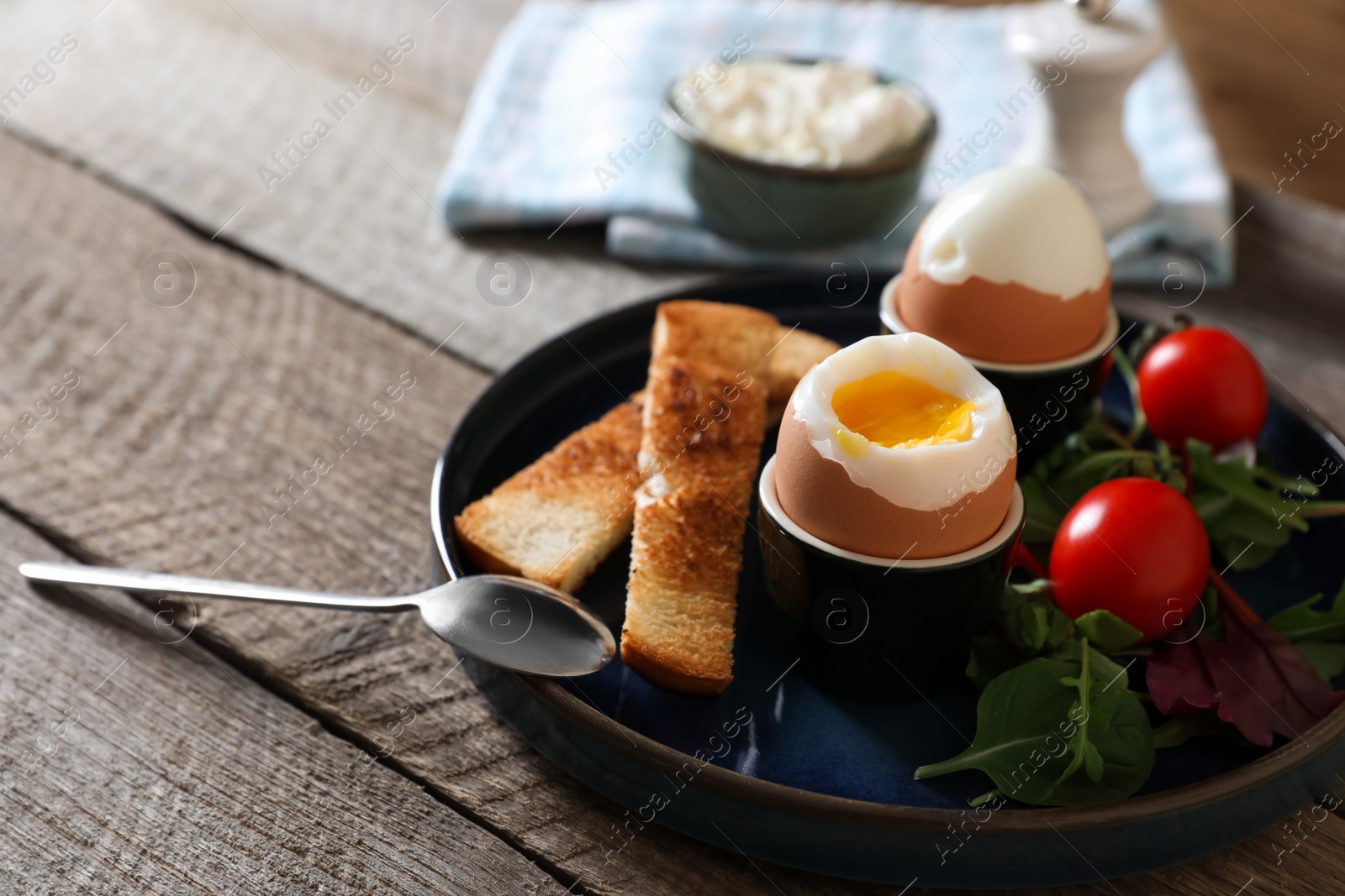 Photo of Delicious breakfast with soft boiled eggs served on wooden table, closeup