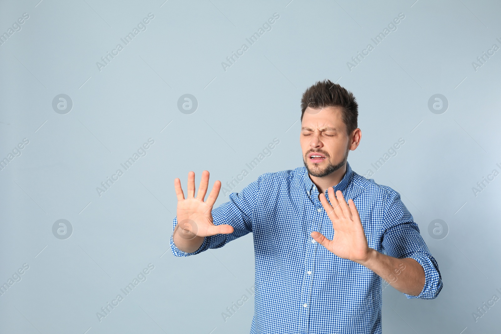 Photo of Handsome man being blinded on grey background