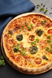 Photo of Delicious homemade vegetable quiche on dark table, top view
