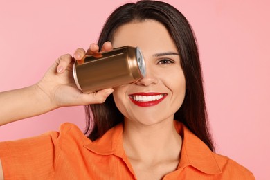 Beautiful young woman in stylish sunglasses holding tin can with beverage on pink background, closeup