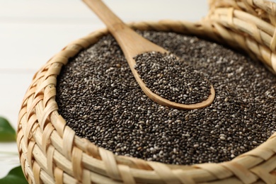 Photo of Wicker box with chia seeds and spoon, closeup